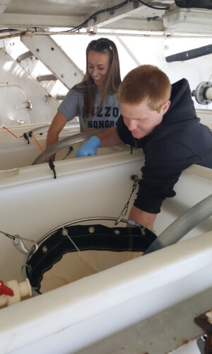 Graduate Students, Holly Doerr and Sean Fitch, homogenizing ballast water sample tank for zooplankton sampling.