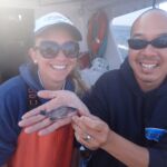Bonnie B. with Captain Allen C. holding a baby Blue Rockfish (Sebastes mystinus) Bonnie B. and Captain Allen C. holding a baby blue rockfish on a CCFRP trip