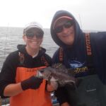 Bonnie B. with Kris H. displaying a Black Rockfish (Sebastes melanops) Bonnie B. and Kris H. holding a black rockfish on a CCFRP trip