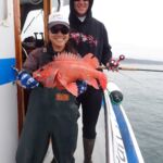 Jen C. with Nick I. holding a Vermilion Rockfish (Sebastes miniatus) Jen C. and Nick I. with a vermilion rockfish on a CCFRP trip