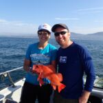 Jackie M. and Jesse R. holding a vibrant Vermilion Rockfish (Sebastes miniatus) Jackie M. and Jessie R. holding a vermilion rockfish on a CCFRP trip