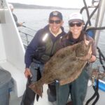 Ken Y. and Jen C. with an unexpected California Halibut (Paralichthys californicus) Ken Y. and Jen C. holding a california halibut on a CCFRP trip