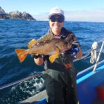 Jen C. displaying her study species, the Yellowtail Rockfish (Sebastes flavidus) Jen C. with a yellowtail rockfish on a CCFRP trip