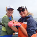 Jenn P. with Bonnie B. delicately holding the smallest catch of the day, a Yellowtail Rockfish (Sebastes flavidus) Jenn P. and Bonnie B. with a tiny yellowtail rockfish on a CCFRP trip