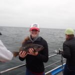 Paige B. cradling an Olive Rockfish (Sebastes serranoides) Paige B. holding an olive rockfish on a CCFRP trip