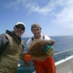Zach K. and Jeff B. with a flatfish a portrait of Zach K. and Jeff B. with aflounder