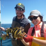 volunteer angler and science crew holding a treefish caught on a CCFRP trip
