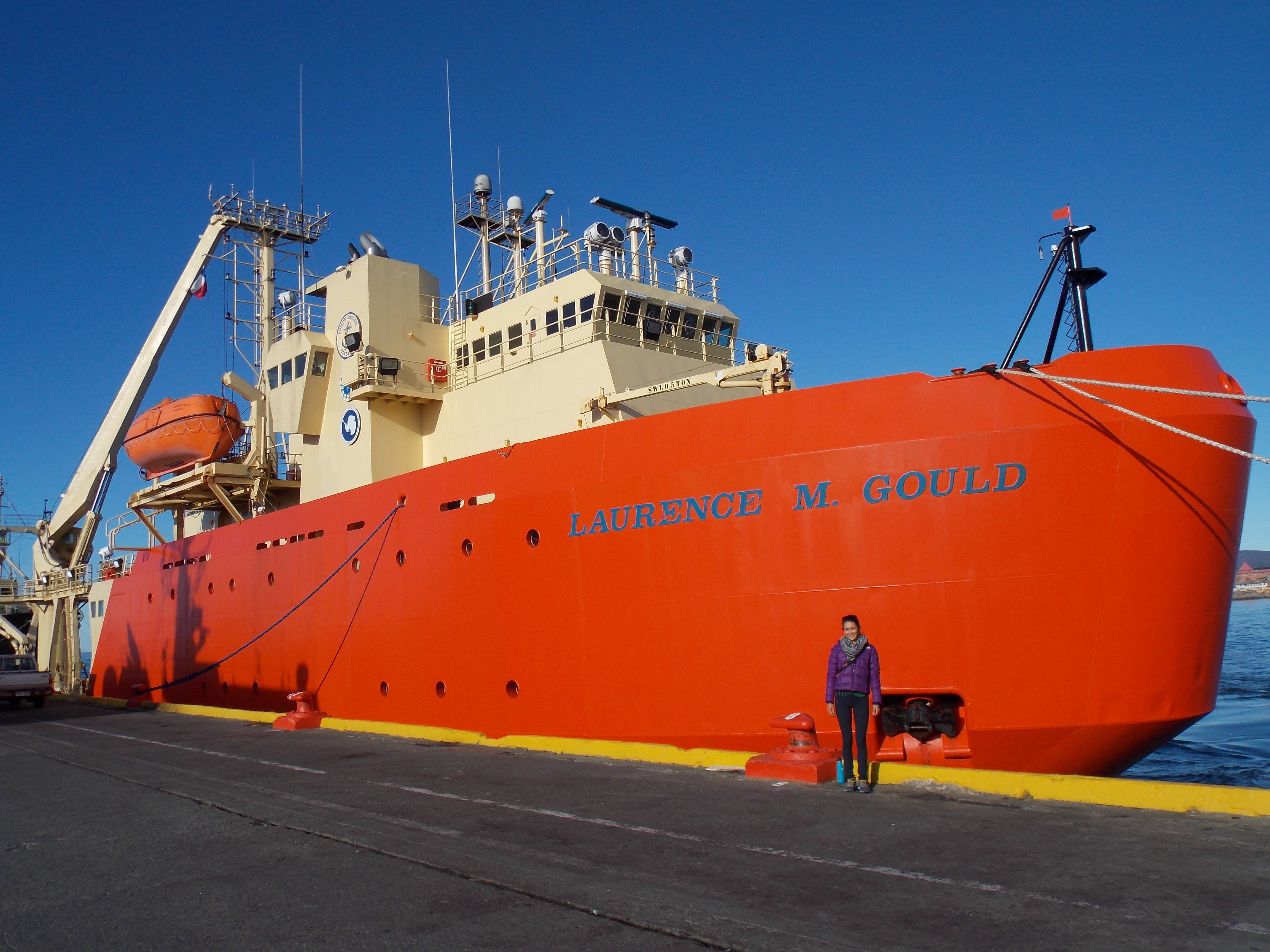 Jamie standing in front of the US's National Science Foundation's icebreaker and research vessel, the Laurence M. Gould, named after an American scientist. 