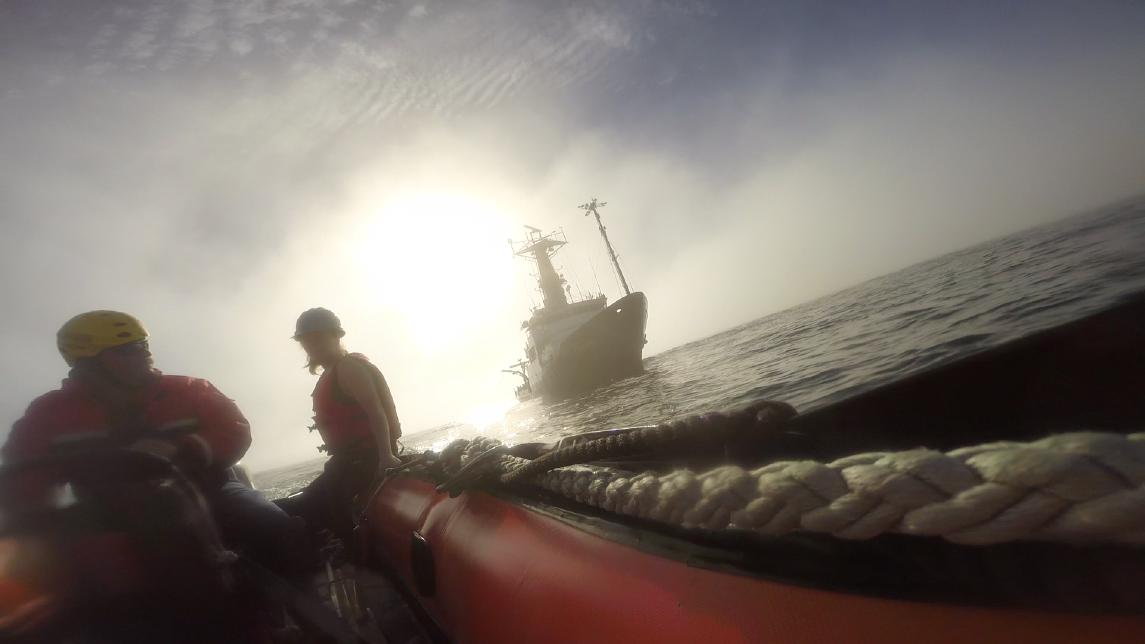 Able Seaman Pat Breshears of Oregon State University’s R/V Oceanus shuttles Holly Chiswell and Alex Olson out into the haze to collect sea surface microlayer samples offshore of Northern California.