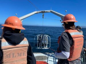 Photo of researchers performing a CTD (conductivity, temperature, depth) cast at sea